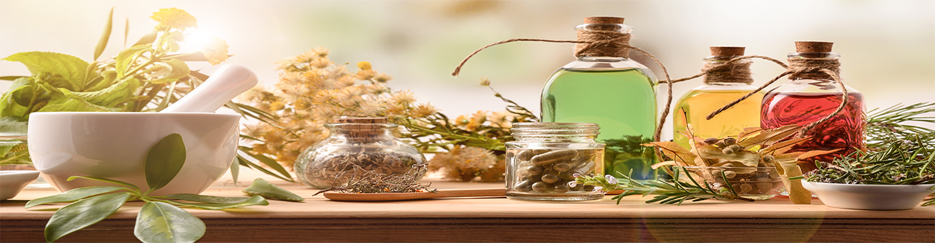 Composition of natural alternative medicine with capsules, essence and plants on wooden table in rustic kitchen. Front view. Horizontal composition.